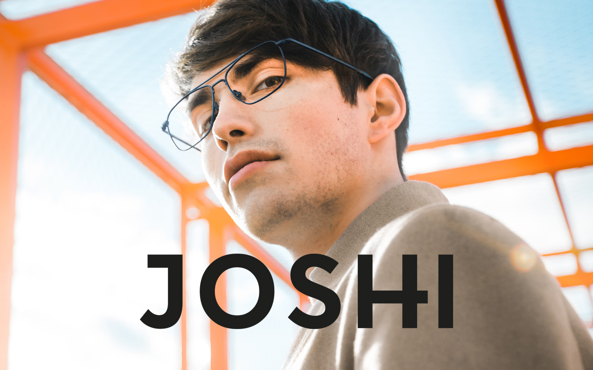 Logo JOSHI Mann mit Brille im Hintergrund